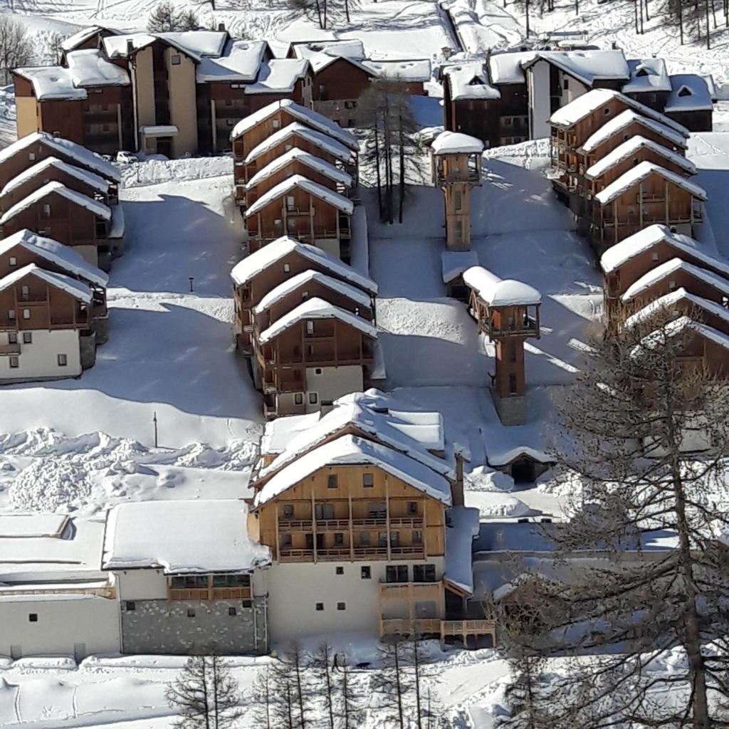 une vue aérienne d'un bâtiment recouvert de neige dans l'établissement residence avec piscine ,chalet des rennes, à Vars