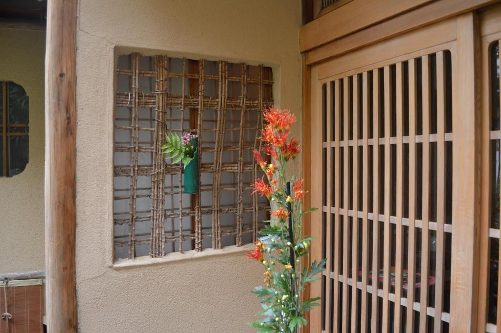 Cette chambre dispose d'une fenêtre avec un vase de fleurs. dans l'établissement Yadoya Manjiro, à Kyoto