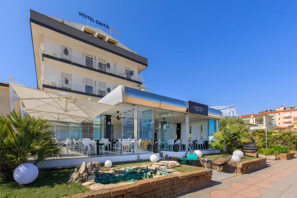 un hôtel avec une piscine devant un bâtiment dans l'établissement Hotel Gritti, à Lido di Jesolo