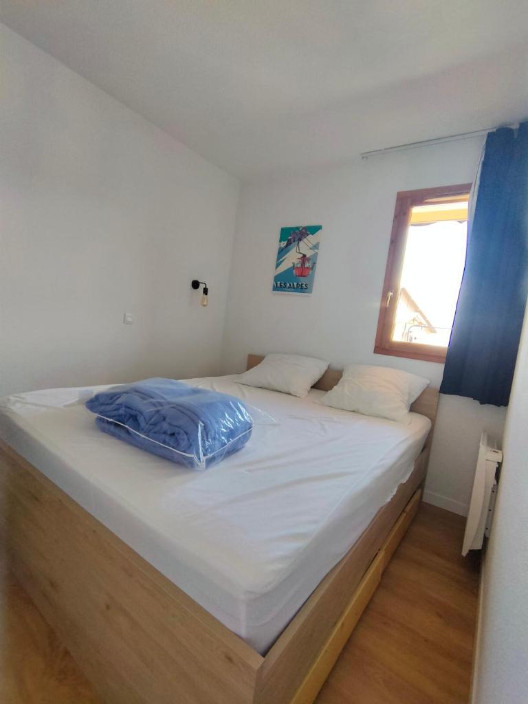 un grand lit dans une chambre avec une fenêtre dans l'établissement Risoul Appartement 2 chambres Piscine Balcons de Sirius, à Risoul 37 autres photos