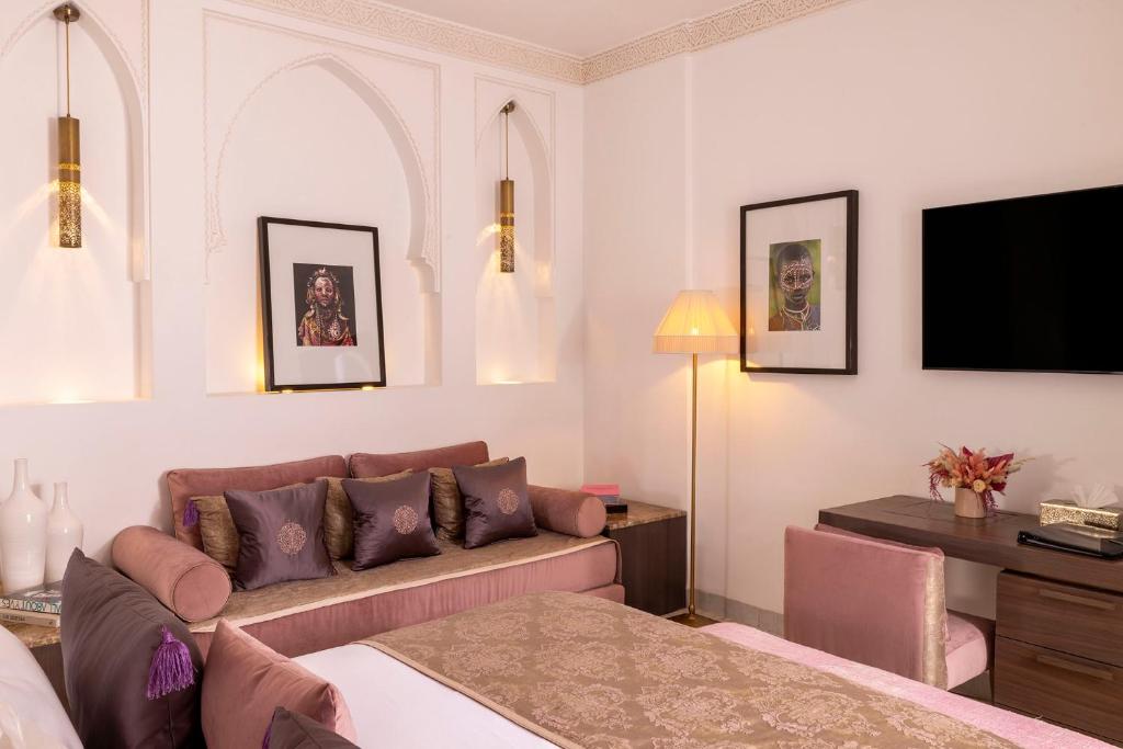un salon avec un canapé et une télévision dans l'établissement Riad LAZ Mimoun & Spa, à Marrakech