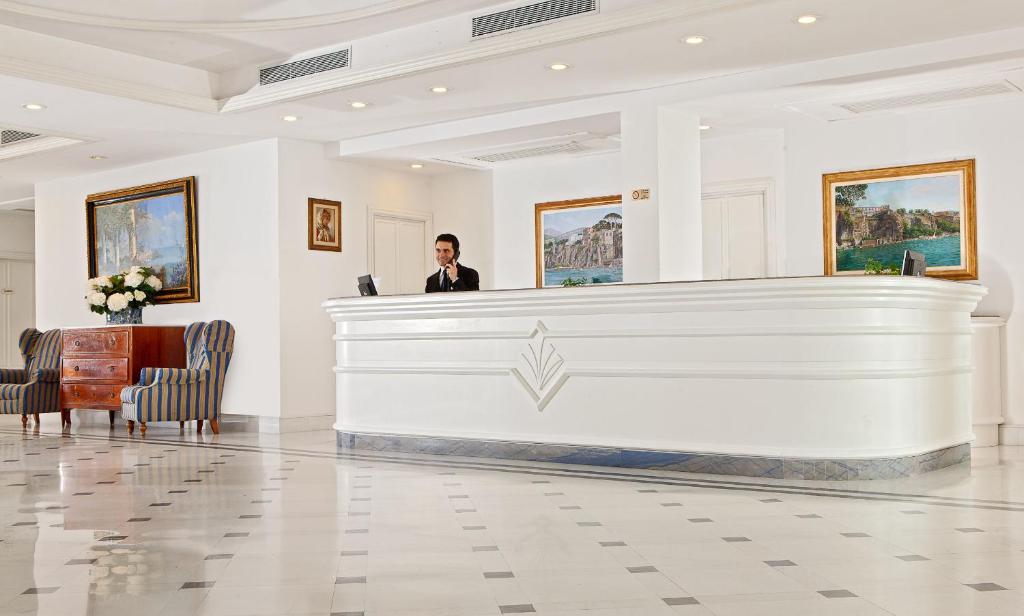un homme debout à un bureau de réception dans un hall dans l'établissement Grand Hotel Riviera, à Sorrente 80 autres photos
