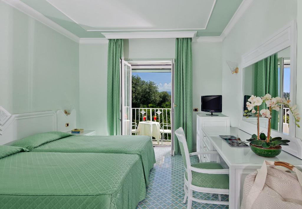 une chambre avec un lit, un bureau et une fenêtre dans l'établissement Grand Hotel Riviera, à Sorrente