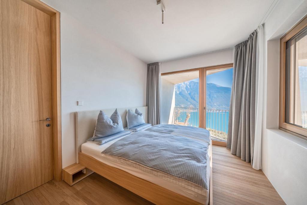 une chambre avec un lit et une grande fenêtre dans l'établissement Villa Arias lake view, à Tremosine