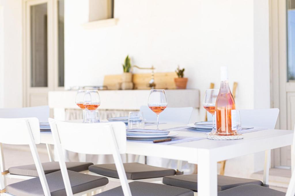 - une table à manger blanche avec des verres de vin dans l'établissement Masseria Macchiaforte, à Gallipoli