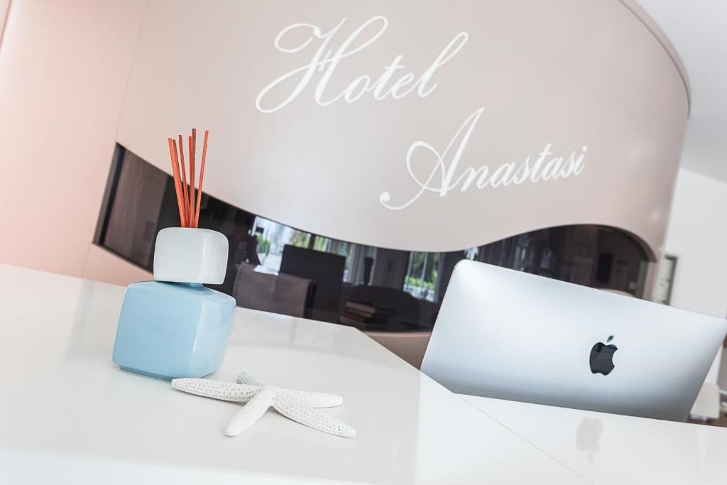 un bureau avec un ordinateur portable Apple et une bouteille d'eau dans l'établissement Anastasi Hotel e Residence, à Cervia