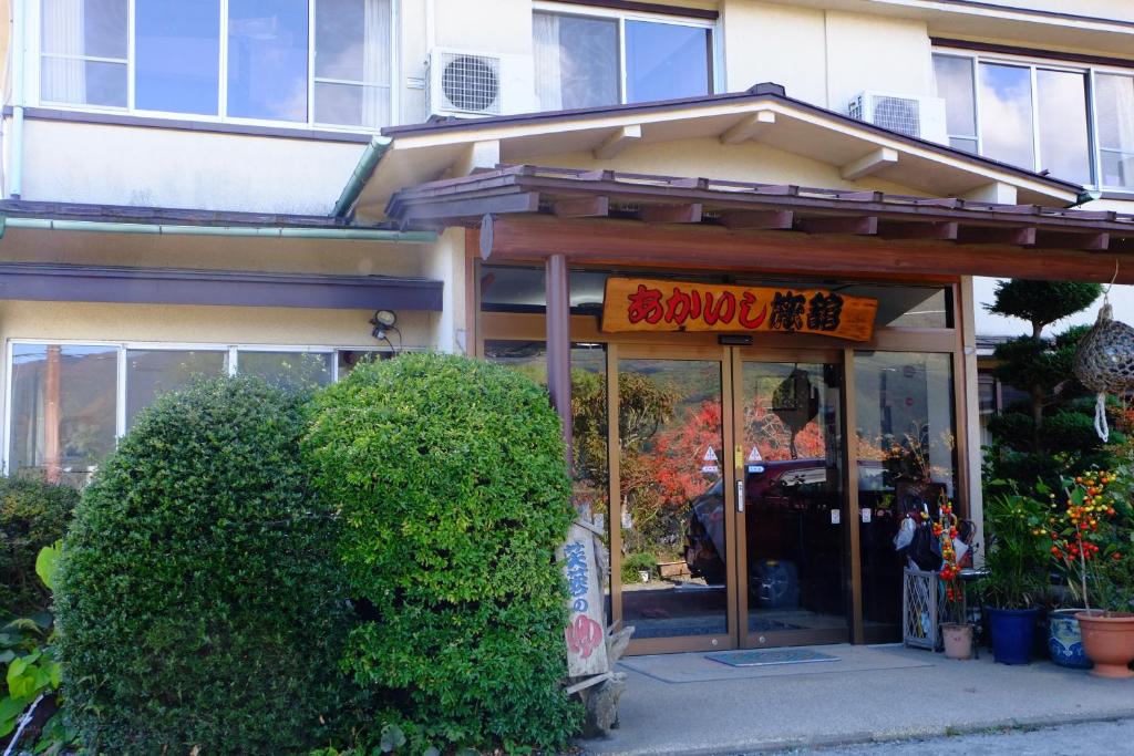 un magasin avec un panneau devant un bâtiment dans l'établissement Akaishi Ryokan, à Fujikawaguchiko