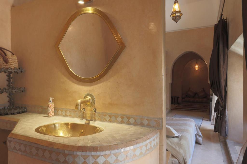 une salle de bain avec un lavabo et un miroir au mur dans l'établissement Dar Warda, à Marrakech