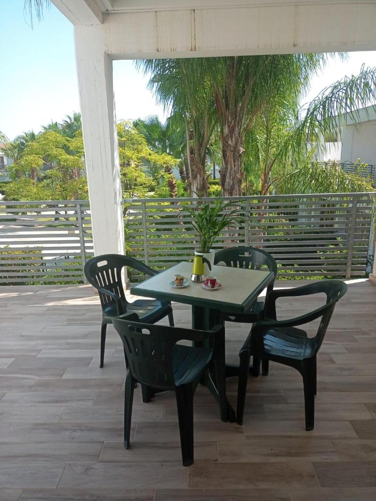 une table et des chaises vertes sur la terrasse dans l'établissement I GIARDINI DI ZEUS, à Métaponte