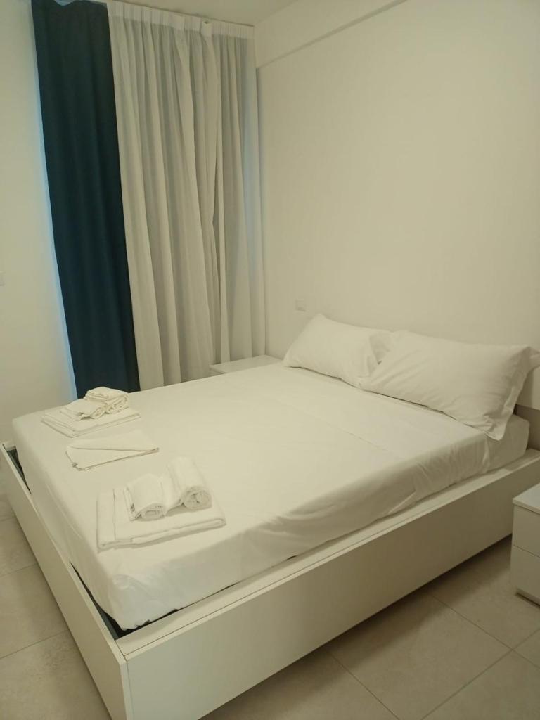 - un lit blanc avec des draps blancs et des serviettes dans l'établissement I GIARDINI DI ZEUS, à Métaponte