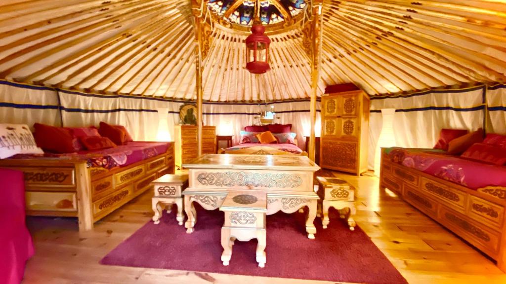- une chambre avec 2 lits et une table dans une yourte dans l'établissement Eco Yourte Les Airelles, à Saint-Anthème