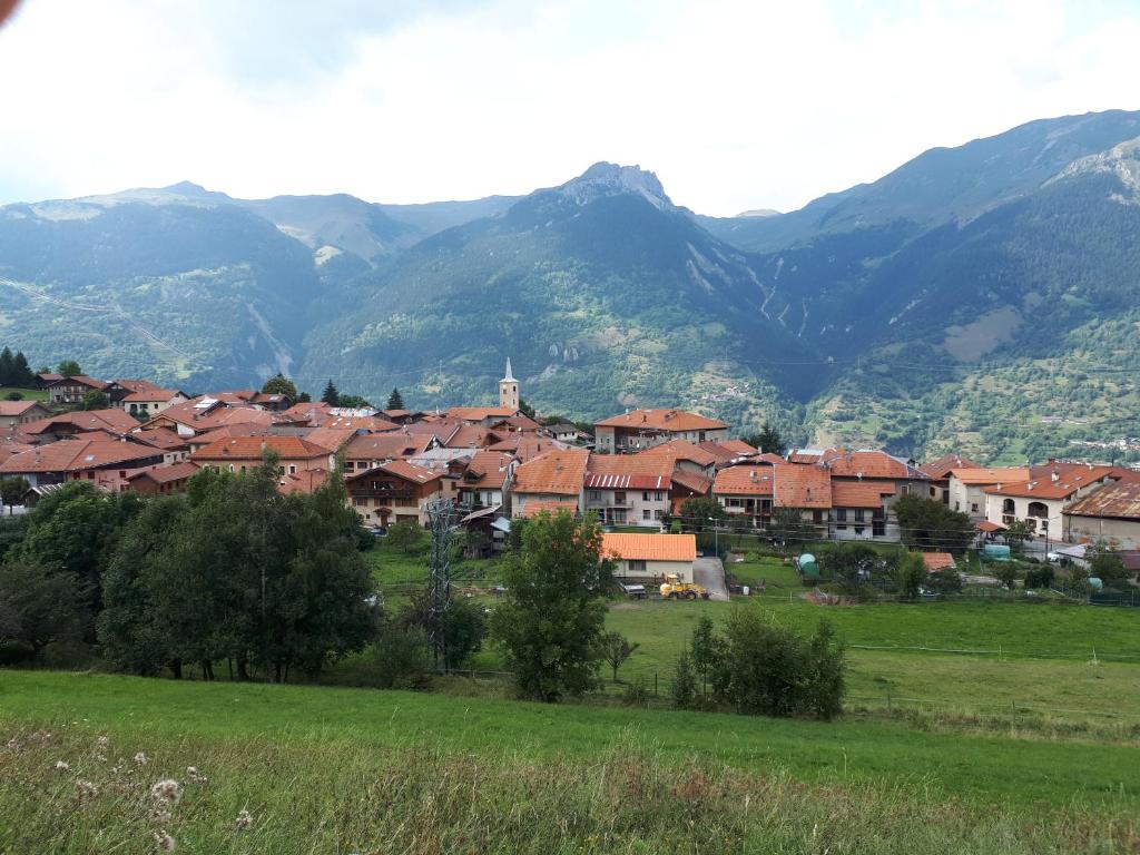 une ville dans un champ avec des montagnes en arrière-plan dans l'établissement Appartement confortable face à la montagne, à Aime La Plagne