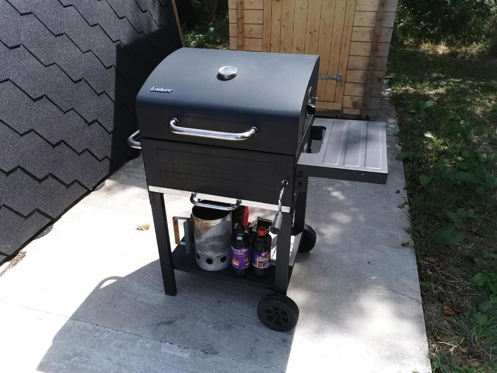 - un grill au charbon de bois avec des boissons sur une voiturette sur un trottoir dans l'établissement Charmant POD en bois près d'un plan d'eau, à Nielles-lès-Ardres