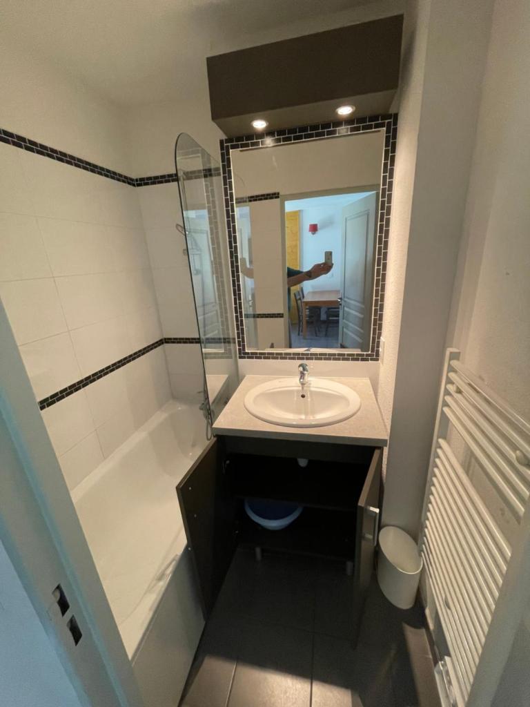 une salle de bain avec un lavabo, une baignoire et un miroir dans l'établissement Appartement Les Chalets de Belledonne, à Saint-Colomban-des-Villards