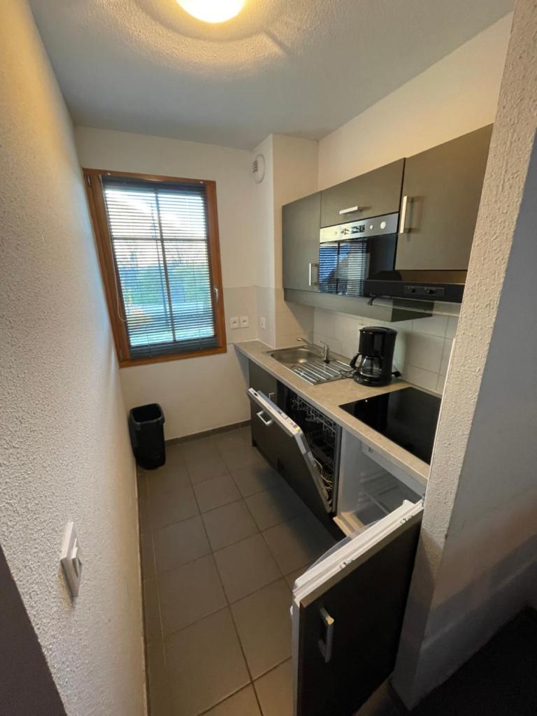 une petite cuisine avec un évier et une cuisinière dans l'établissement Appartement Les Chalets de Belledonne, à Saint-Colomban-des-Villards