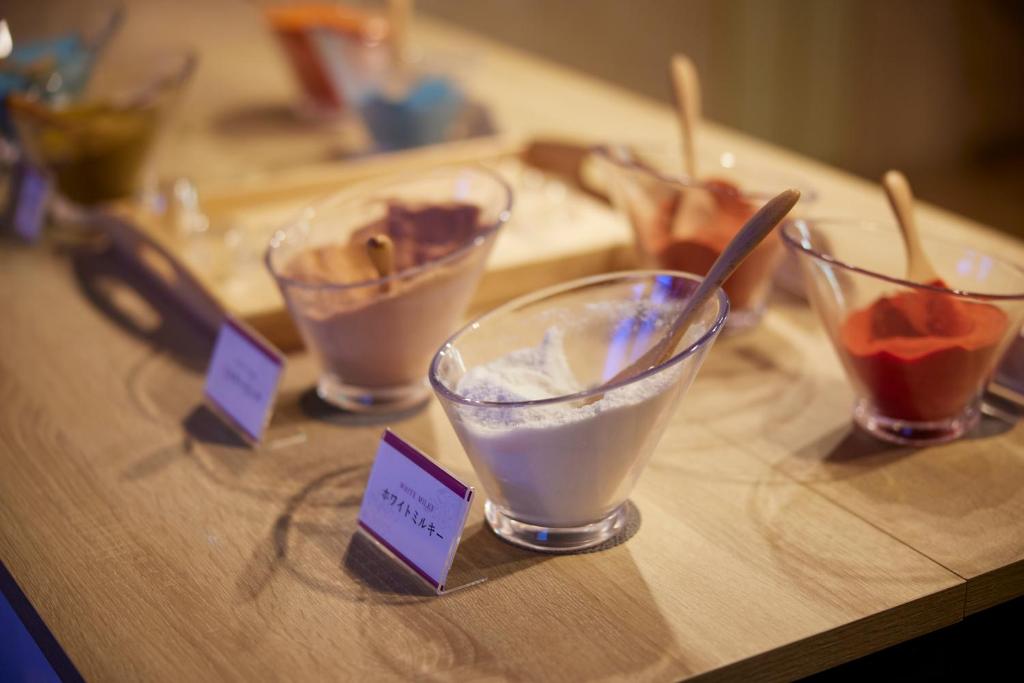 une table en bois avec quatre bols de crème glacée dans l'établissement HOTEL WiLL EX 大高 レジャーホテル, à Nagoya