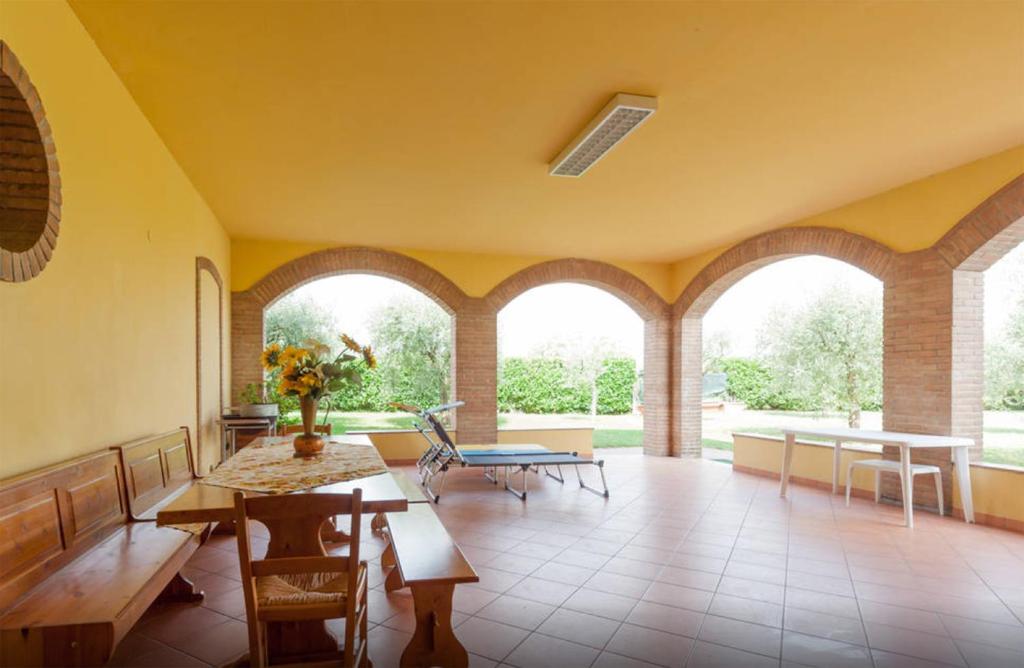 - un salon avec des fenêtres cintrées, une table et des chaises dans l'établissement TABACHERA x10 Cascina with Private Pool Sirmione GARDA LAKE, à Pozzolengo