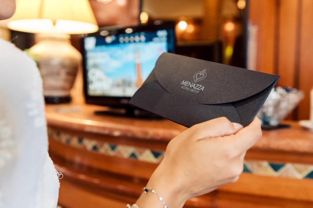 une femme tenant un morceau de papier dans sa main dans l'établissement Hotel Brioni Mare, à Lido di Jesolo