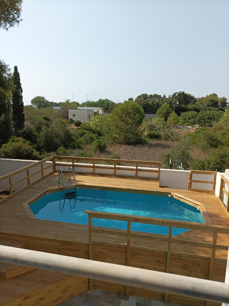 une piscine avec une terrasse en bois et une visière de piscine dans l'établissement Vele del Pizzo - piscina, à Gallipoli