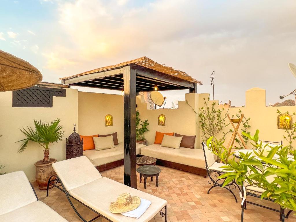 un patio avec un canapé, des tables et des chaises dans l'établissement Riad des Lys, à Marrakech 37 autres photos