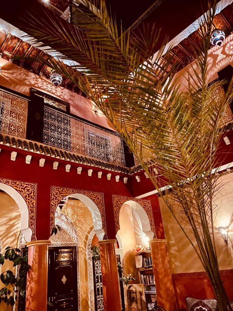 une chambre avec un palmier dans un bâtiment dans l'établissement Riad Naya, à Marrakech