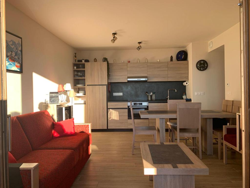 un salon et une cuisine avec un canapé et une table dans l'établissement LE RIDGE nouvelle résidence prestige - Les Arcs Paradiski, à Bourg-Saint-Maurice