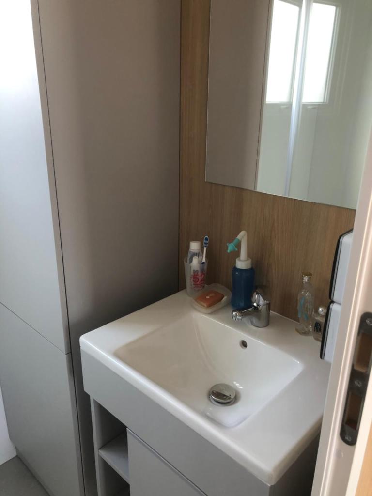 une salle de bain avec un lavabo blanc et un miroir dans l'établissement Camping le Castellas, à Sète 17 autres photos