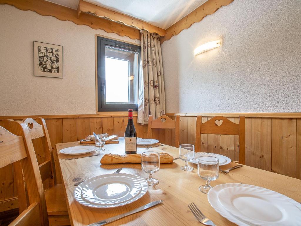 - une table en bois avec une bouteille de vin et des verres dans l'établissement Apartment Vanoise 751 by Interhome, à Val Thorens