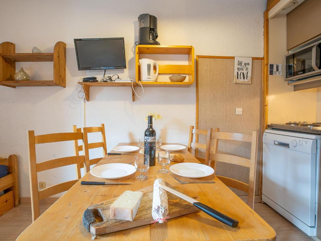 - une cuisine avec une table en bois et une bouteille de vin dans l'établissement Apartment Arcelle 203 by Interhome, à Val Thorens