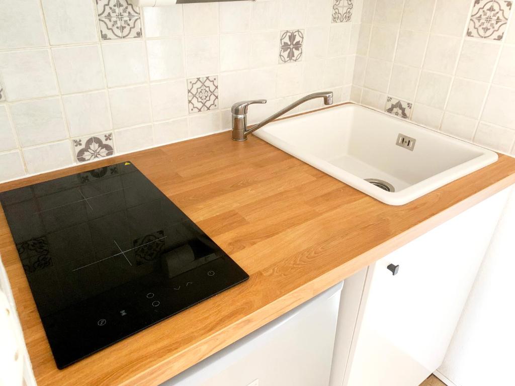 - une cuisine équipée d'un évier et d'une tablette sur un comptoir dans l'établissement Appartement avec balcon au pied des pistes de ski, à Villarembert