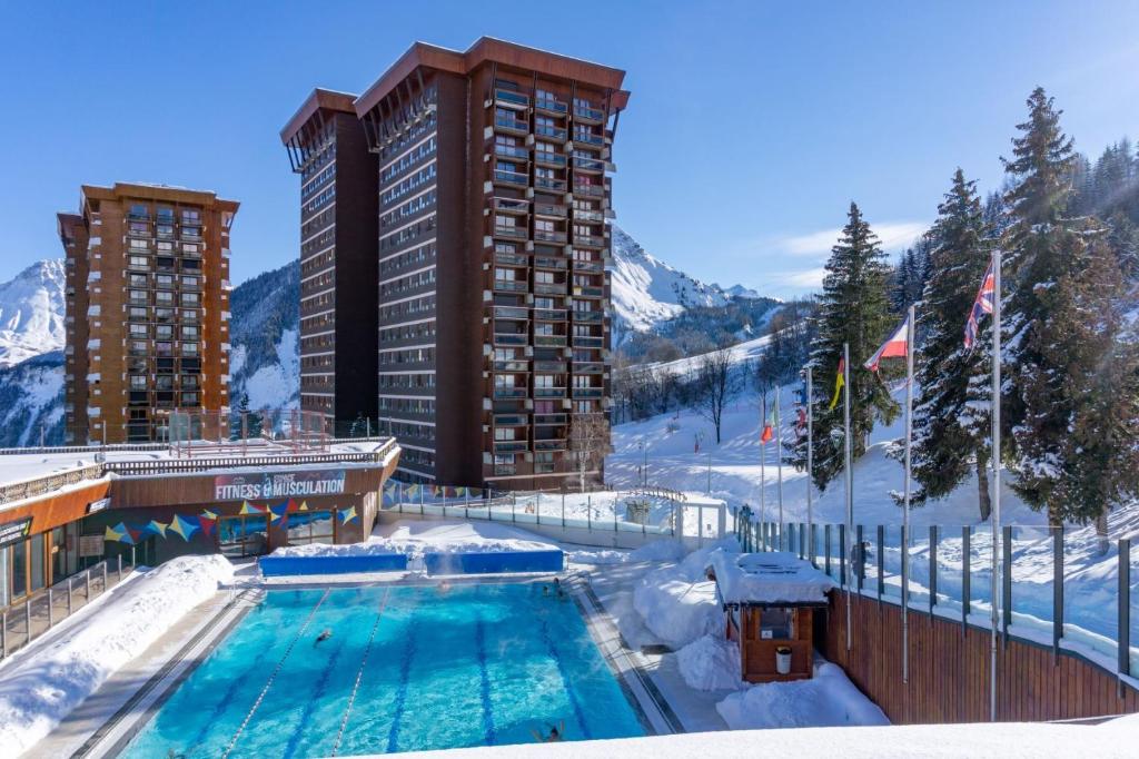 une piscine dans la neige à côté d'un bâtiment dans l'établissement Appartement avec balcon au pied des pistes de ski, à Villarembert