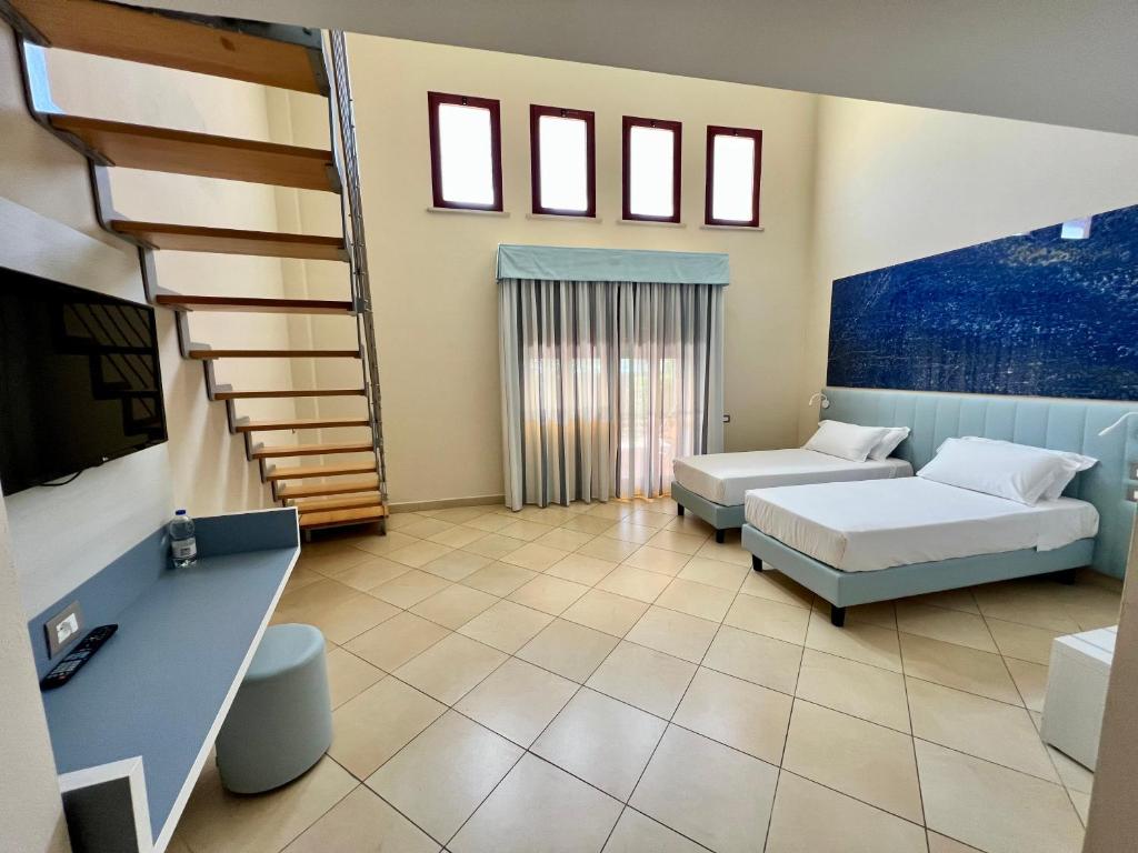 une chambre avec deux lits et un escalier dans l'établissement Toscana Sport Resort, à Tirrenia