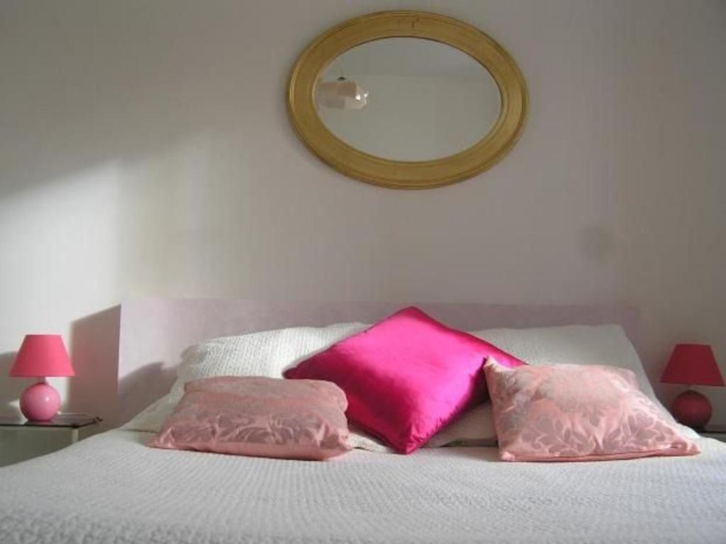 - un lit avec 2 oreillers roses et un miroir dans l'établissement Gîte Champêtre avec Piscine Chauffée, Cheminée, et Terrasse en Plein Sud - FR-1-410-131, à La Chapelle-aux-Choux
