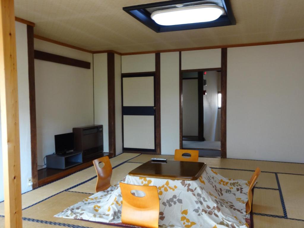 - un salon avec une table, des chaises et une télévision dans l'établissement Oomukou Ryokan, à Hakuba