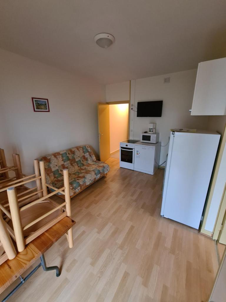 - un salon avec un canapé et un réfrigérateur dans l'établissement Ski-to-door apartment au Collet d'Allevard, à Allevard