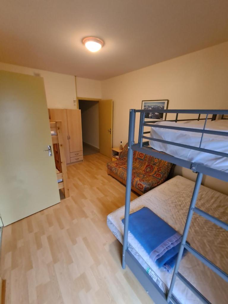 Cette chambre comprend 2 lits superposés et un couloir. dans l'établissement Ski-to-door apartment au Collet d'Allevard, à Allevard