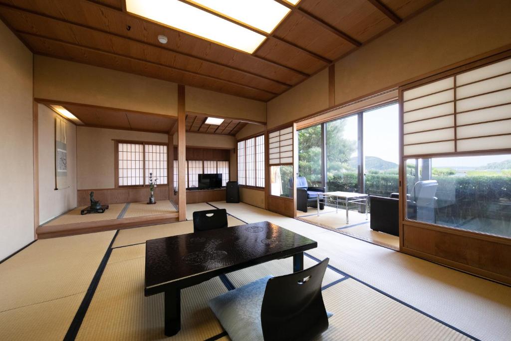 un salon avec une table et une grande fenêtre dans l'établissement Mizuno Ryokan, à Karatsu
