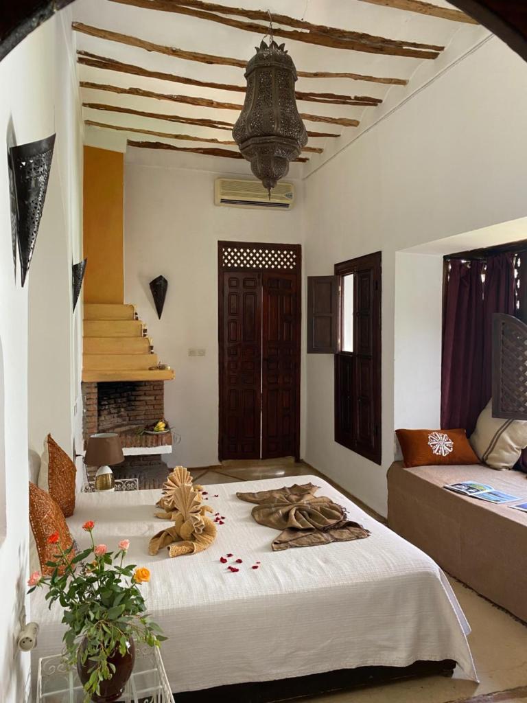 une chambre avec un lit et une cheminée dans l'établissement Dar Soukaina, à Marrakech