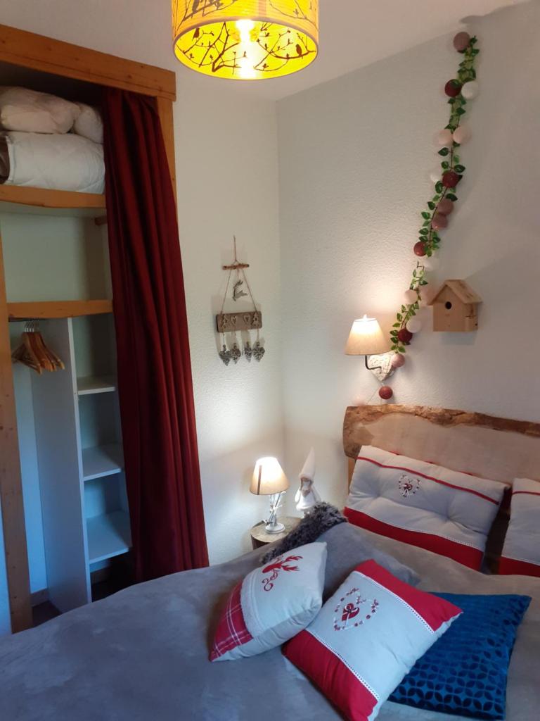 une chambre avec deux lits et un lustre dans l'établissement VALFREJUS - Appartement "L'Erable" Les Chalets de Florence 2 - Chaleureux et fonctionnel - plein centre à côté des télécabines - 4 à 7 pers, à Valfréjus