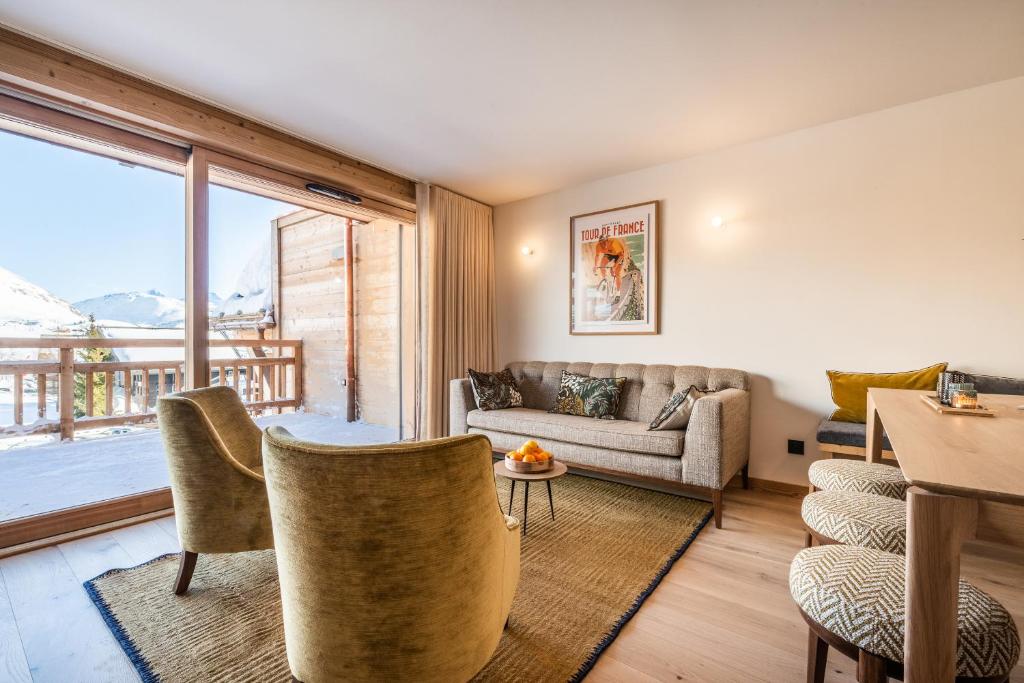 un salon avec un canapé et une table dans l'établissement Apartment Sipo Alpe D'Huez - by EMERALD STAY, à L'Alpe-d'Huez