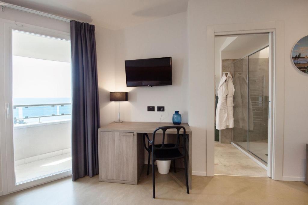 Cette chambre dispose d'un bureau, d'une télévision et d'une douche. dans l'établissement Grand Hotel Faraglioni, à Aci Trezza
