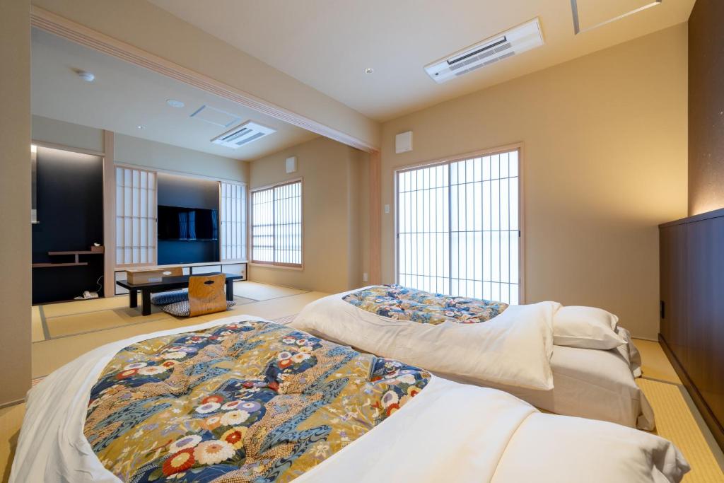 une chambre avec deux lits et un salon dans l'établissement Nishiyama Ryokan - Established in 1953, à Kyoto