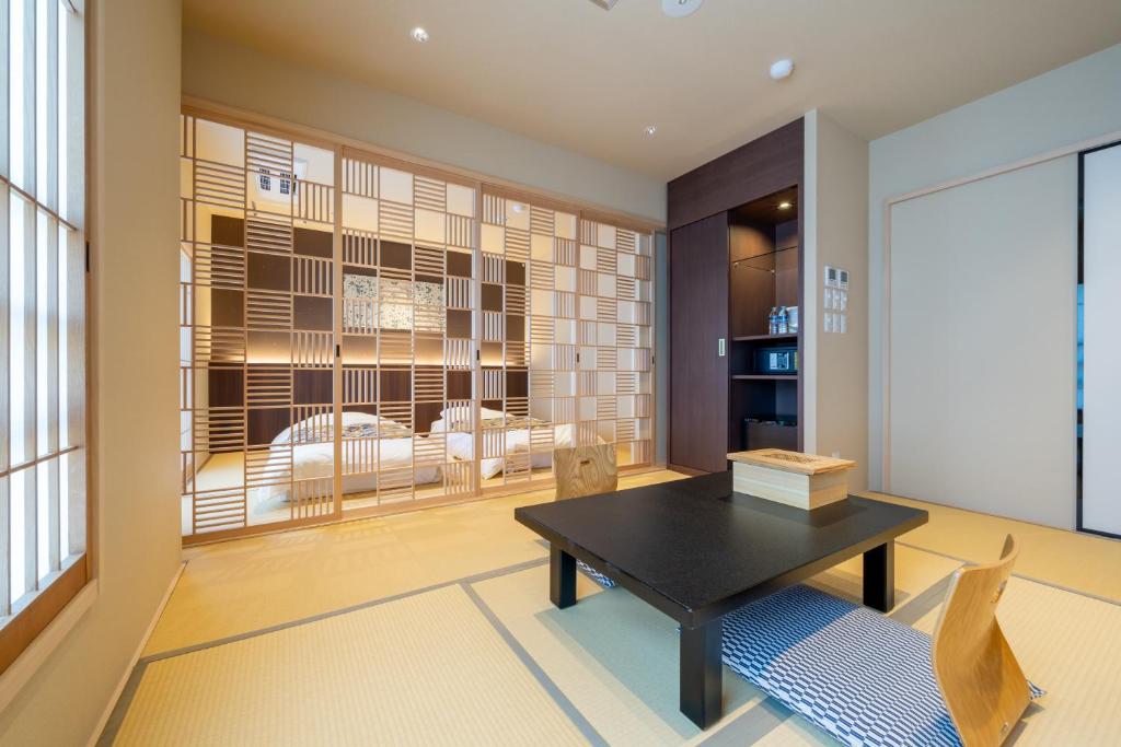 une salle à manger avec une table et des chaises noires dans l'établissement Nishiyama Ryokan - Established in 1953, à Kyoto