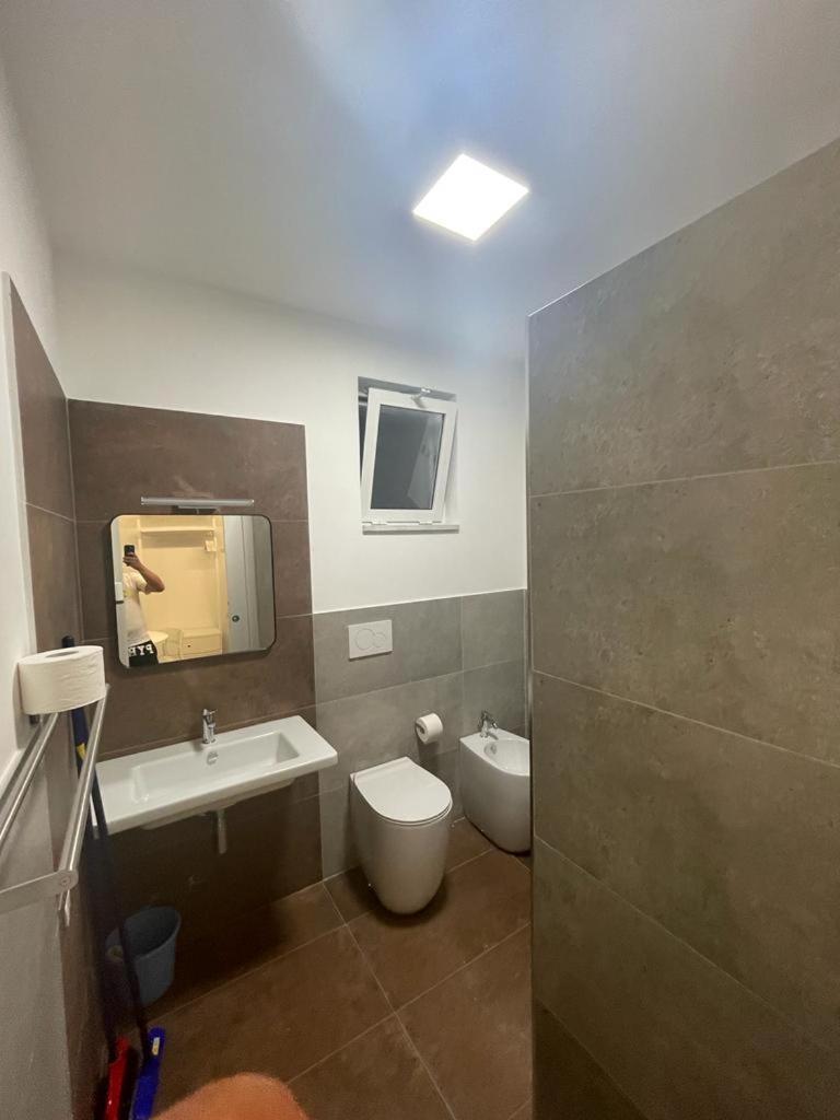 une salle de bain avec un lavabo, des toilettes et un miroir dans l'établissement Residence Adriatico, à Mattinata