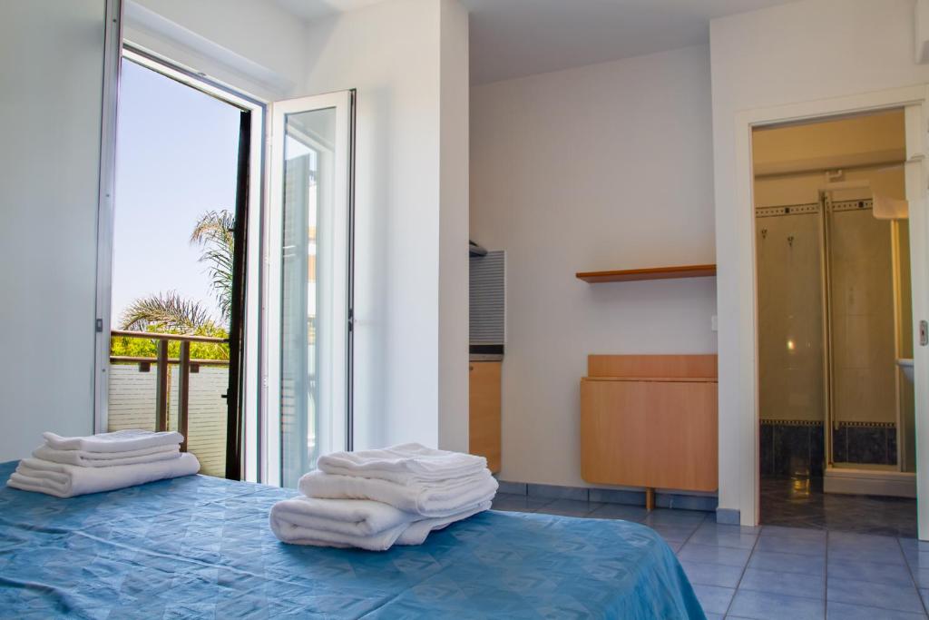 une chambre avec un lit et des serviettes. dans l'établissement Residence Playa, à Tortoreto Lido