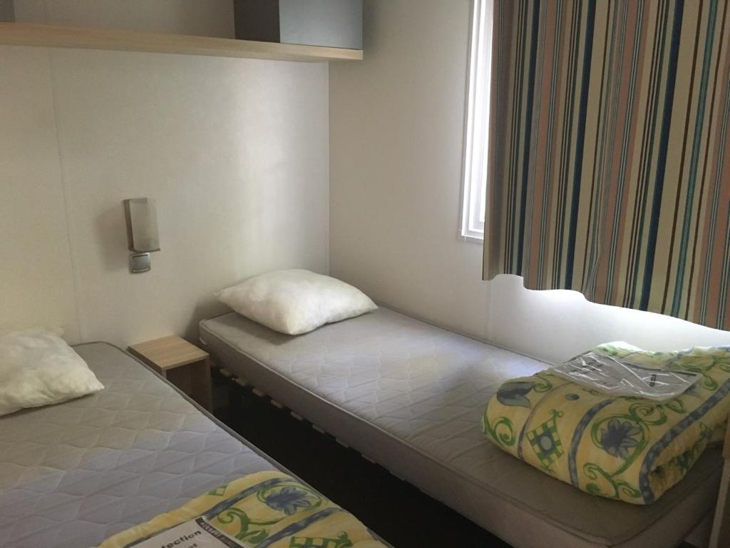 deux lits dans une petite pièce avec une fenêtre dans l'établissement domaine de la sainte baume, à Nans-les-Pins