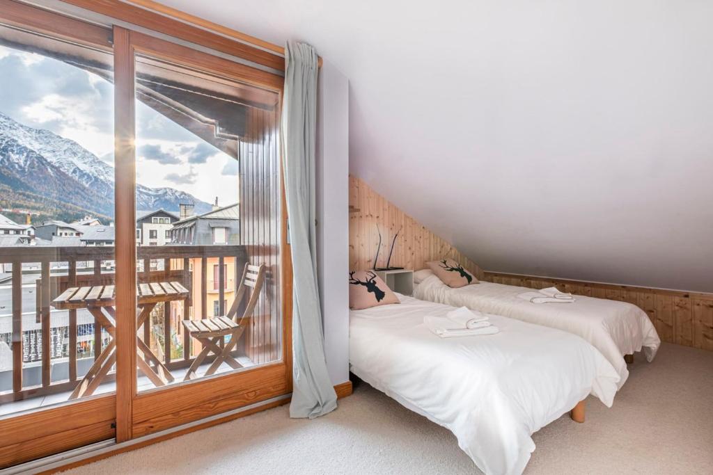 deux lits dans une chambre avec balcon dans l'établissement Nice 55 M With Balconies And Mont Blanc View, à Chamonix-Mont-Blanc 1 autre photo