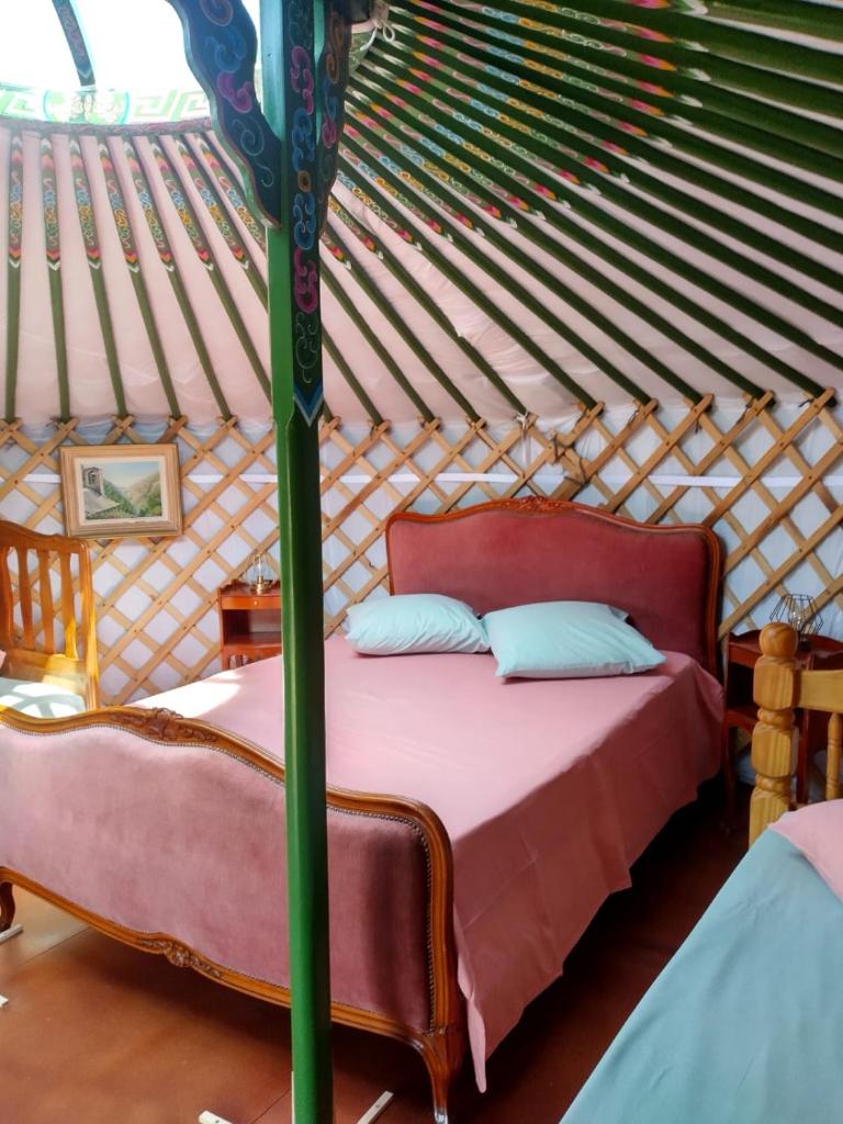 une chambre avec un lit dans une yourte dans l'établissement Yourtes Lacroutz, à Nassiet