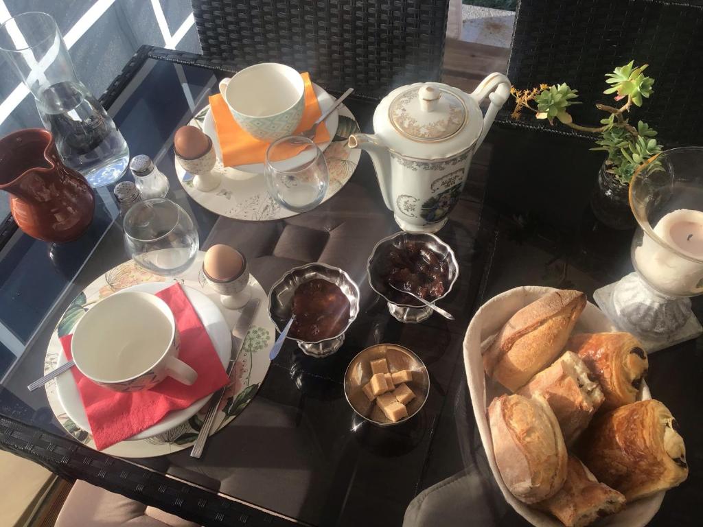 - une table en verre avec un plateau de nourriture, de tasses et de pain dans l'établissement Yourtes Lacroutz, à Nassiet 37 autres photos