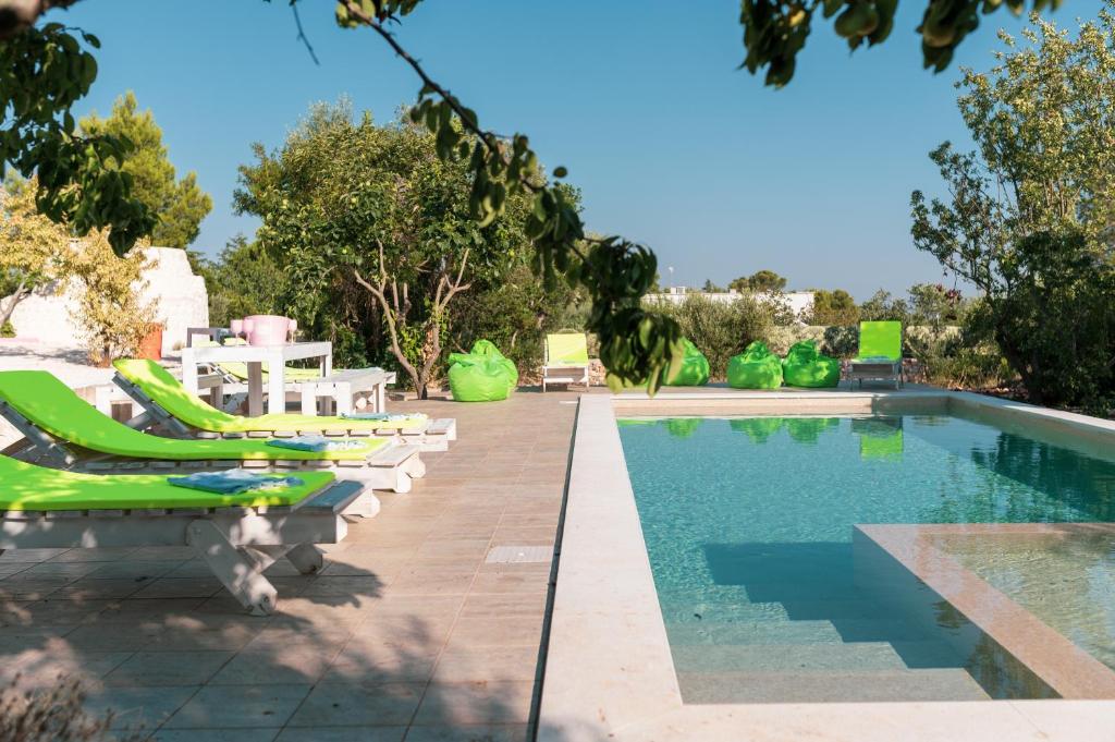 - une piscine avec chaises longues à côté de la piscine dans l'établissement Ostuni Hills Boutique Villa-AC in every room, à Ostuni